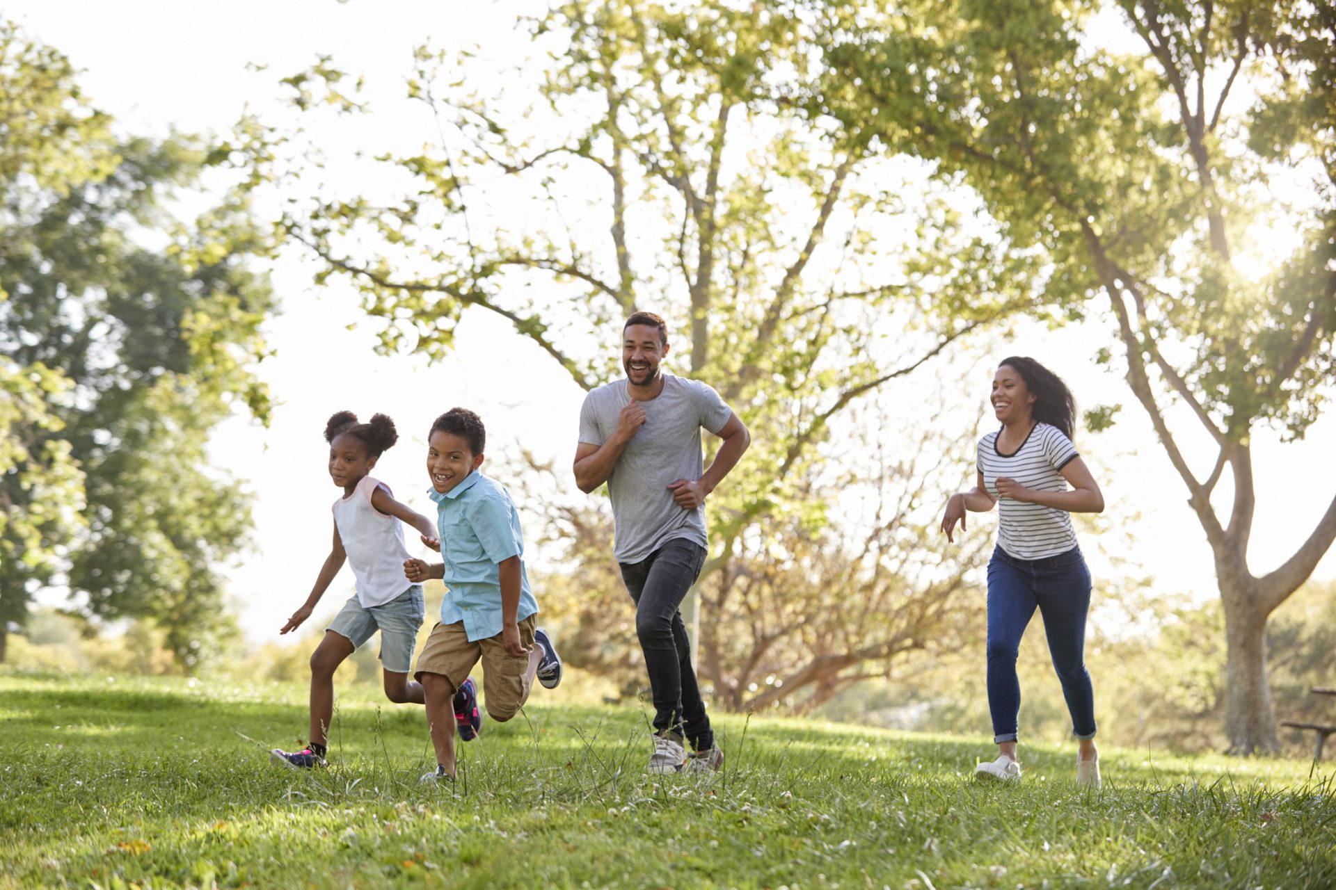 Family Running Through Park Together